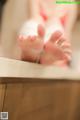 A woman in a bathtub with her feet in the water.