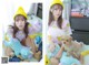 A woman sitting on a bed with a stuffed animal and a dog.