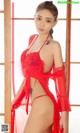 A woman in a red lingerie posing for a magazine cover.